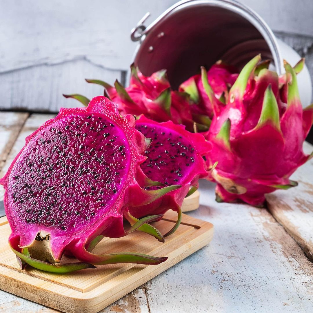 Owner-supplied American Beauty photograph: magenta-fleshed cut dragon fruit with whole pink fruits